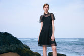 A woman wearing a black A-line dress